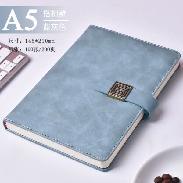 Elegant soft blue A5 notebook with textured cover, clasp, perfect for corporate gifts.