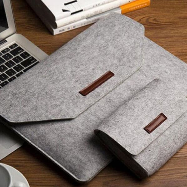 Stylish gray felt laptop sleeve and pouch set for organized, modern workspace elegance.