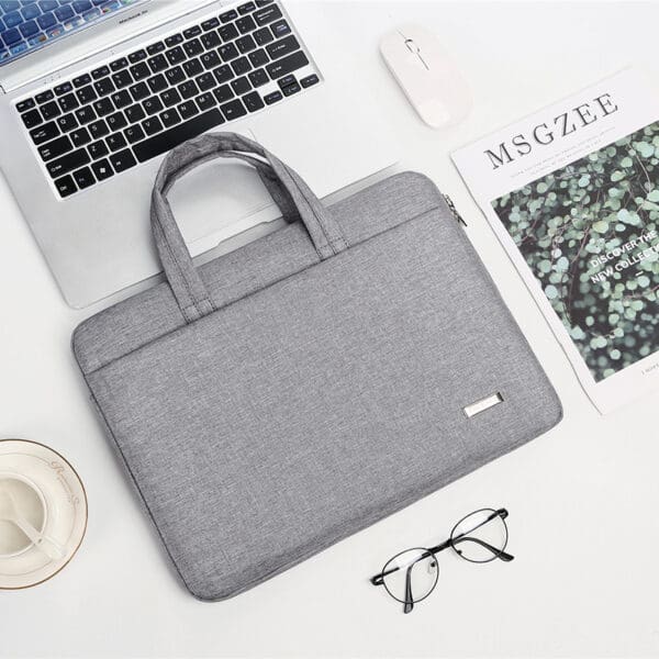 Sleek gray laptop bag and accessories in a modern workspace, perfect for corporate gifting.