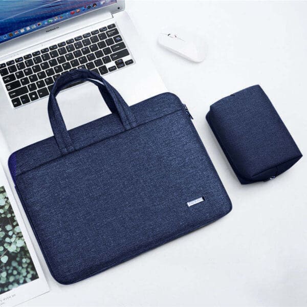 Modern workspace featuring a sleek laptop, navy bag, white mouse, and stylish speaker.