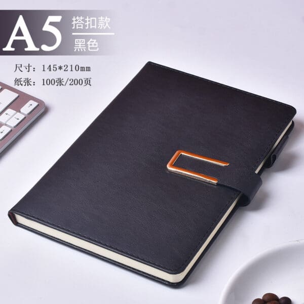 Sleek black A5 notebook with orange clasp, perfect corporate gift for professionals.