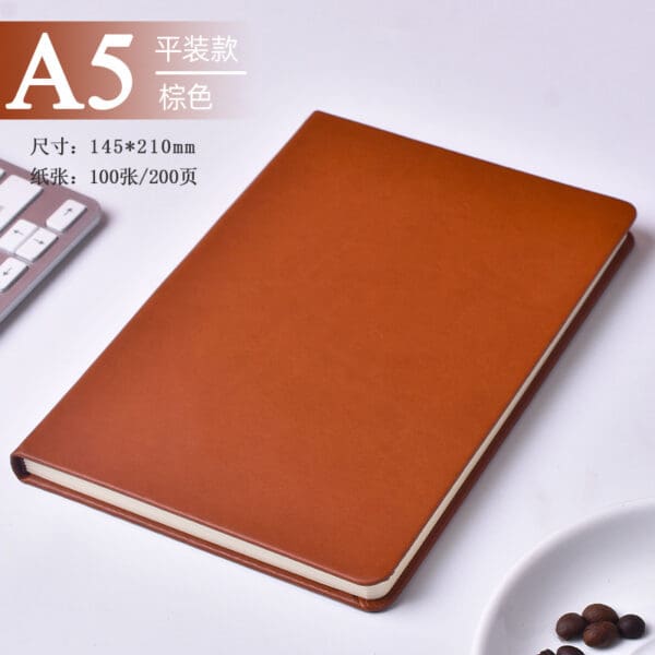 Sleek brown notebook and coffee beans in a modern workspace, perfect for creativity.