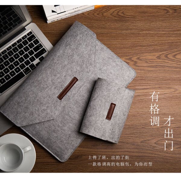 Minimalist workspace with wooden desk, sleek laptop, felt accessories, and a coffee cup.
